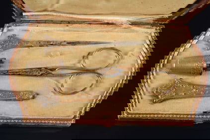 Antique gilt and jeweled silver sewing set. White and pink stones on pick, needle case, and thimble.