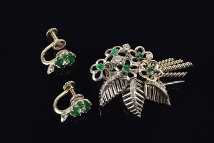 Vintage platinum diamond and emerald mounted pin and earrings. Pin with reticulated floral and