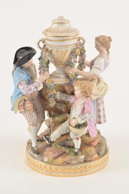 Meissen figural group of figures wrapping a floral garland around a an urn, under glazed blue mark,