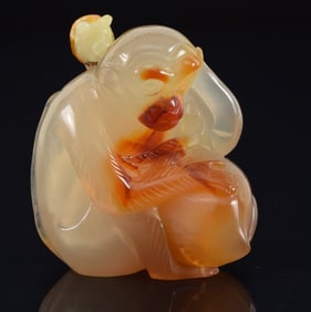Agate snuff bottle. China. Ca. 1850. Carved in the round as a monkey with peaches. Well hollowed.