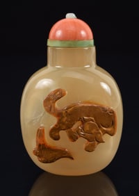 Agate snuff bottle. China. Ca. 1850. Skin carved with a foo dog and crow. Coral pearl set stopper.