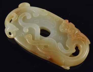 Jade pendant. China. 18th century. Oval form carved with a chih lung and archaic motifs. Celadon