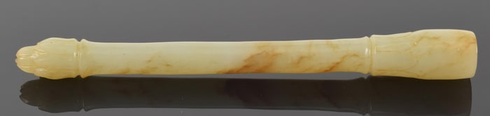 Jade brush handle. China. 18th century. Yellow stone with brown markings carved with lotus motifs.