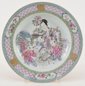 Porcelain plate. China. Ca. 1750. Famille rose decoration of women and children. Brocaded borders.