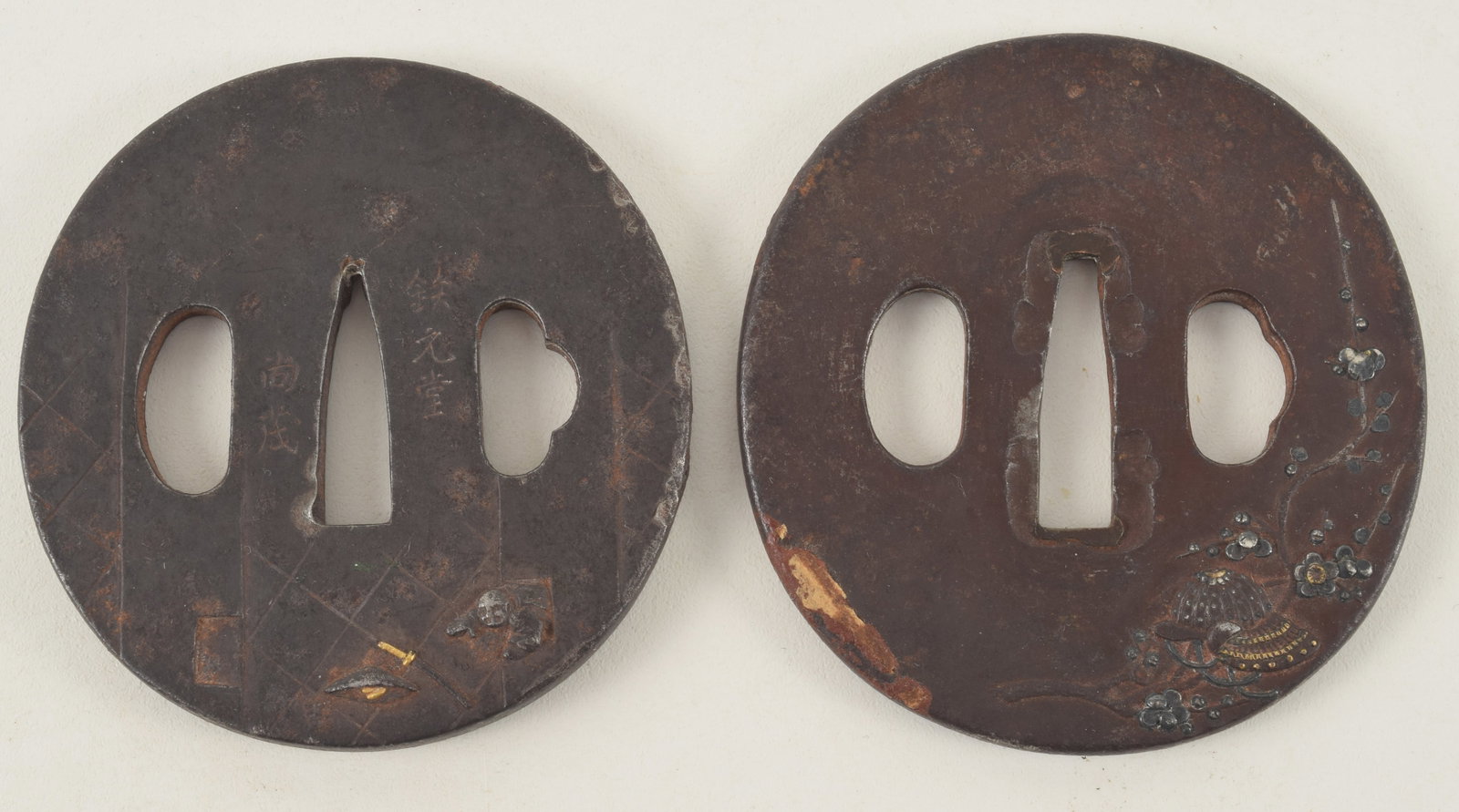 2 sword guards. Japan. 19th century. Iron tsuba with gold and silver inlay.: 2 sword guards. Japan. 19th century. Iron tsuba with gold and silver inlay.