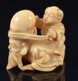Netsuke of a child rubbing Jinjuro's head. Japan. 19th century. Signed. 1.5in.