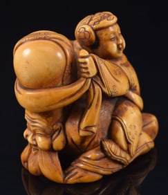 Netsuke of a child rubbing Jurojin's head. Japan. 19th century. Signed. 1.75in.