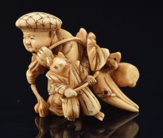 Netsuke of Daiko-ku and a mouse hauling vegetables. Japan. 19th century. 1.5in length.