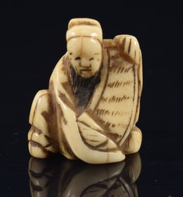 Ojime of a poet holding a scroll. Japan. 19th century. 1/2in length.