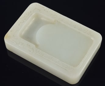 Jade inkstone. China. 18th century. Pale green stone carved with archaic scrolling. 3.5 x 2.25in.