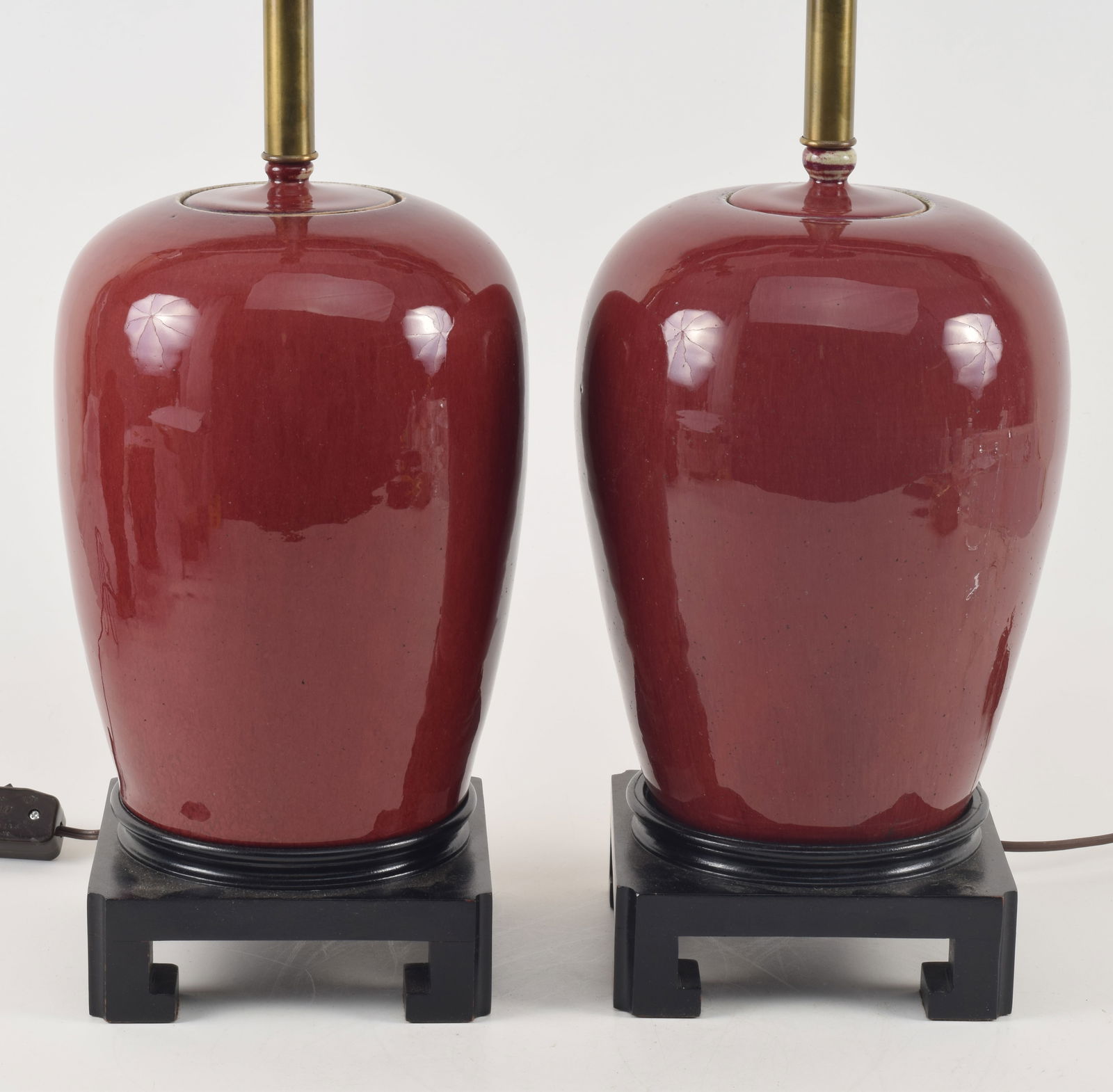 Pair of oxblood covered jars. China. Early 20th century. Ovoid form. Drilled and mounted as lamps.: Pair of oxblood covered jars. China. Early 20th century. Ovoid form. Drilled and mounted as lamps. Overall 29in.