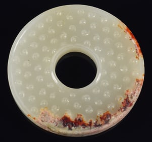 Jade pi. China. Pure white stone with russet markings. 2in diameter.