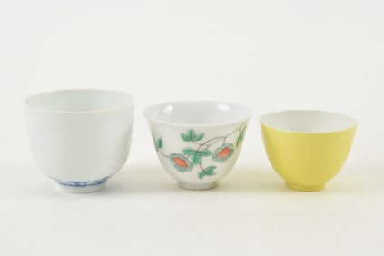 3 porcelain wine cups. China. 19th century. Underglaze blue, yellow and Cheng Hua Ming style. Each