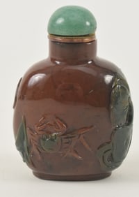 Agate snuff bottle. China. Ca. 1850. Reddish stone with a green area carved as a crab and aquatic