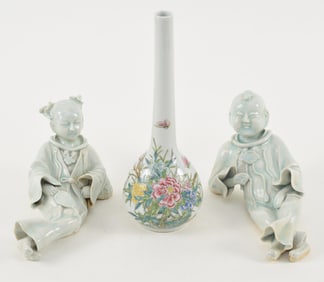 3 porcelains. China. 20th century. A pair of reclining figures with a celadon glaze. 9in long.