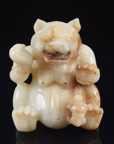 Jade carving. China. 20th century. Han style. White stone with brown markings. Study of a bear with