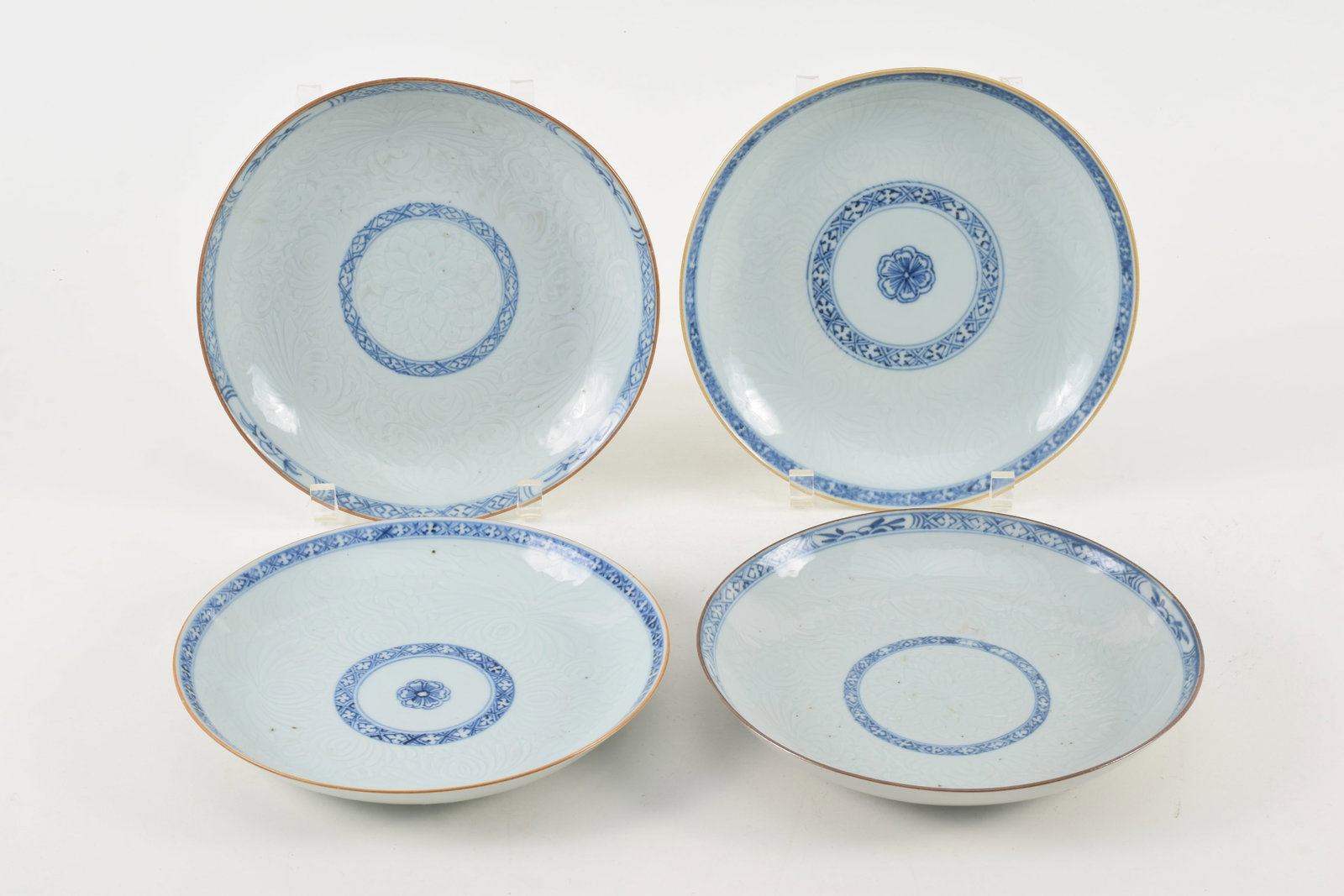4 Chinese blue and white porcelain plates. 19th century. Underglaze carved scrolling decoration.: 4 Chinese blue and white porcelain plates. 19th century. Underglaze carved scrolling decoration.