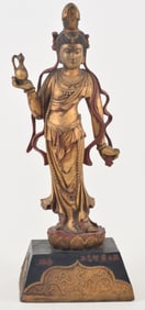 Carved wooden image of Kuan Yin. China. 20th century. Gilt, red and gold lacquer surface. 22in.