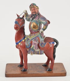 Porcelain figure of a Kuan Ti on a horse. China. 20th century. 14 x 9in.