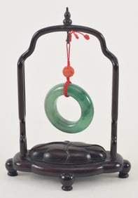 Jadeite ring. 20th century. Fine highly translucent bright green stone. 2in. Hardwood frame.