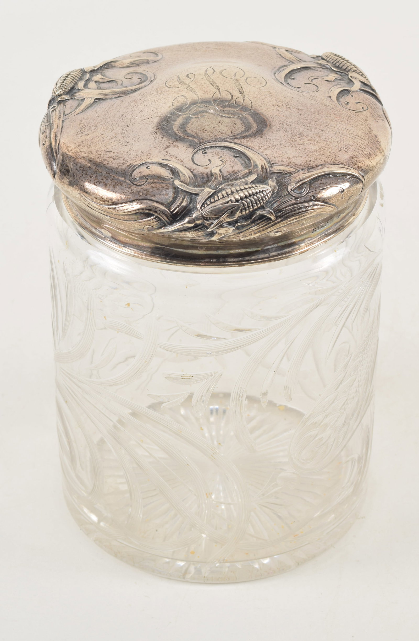 Sterling silver covered cut glass humidor. Thistle pattern cut glass decoration. Sterling cover with: Sterling silver covered cut glass humidor. Thistle pattern cut glass decoration. Sterling cover with corn cobb decoration. 6.75in high. 5in diameter. Silver cover weighs 4.3 ozt.