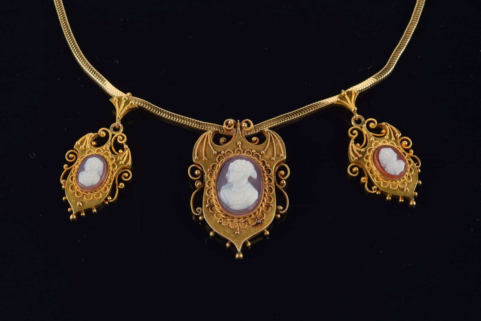 Antique 14K gold pin and earring set set with shell carved cameos on winged shield form setting with: Antique 14K gold pin and earring set set with shell carved cameos on winged shield form setting with bead and wire work accents. Repurposed and mounted to a vintage Forstner 14K gold necklace. Necklac