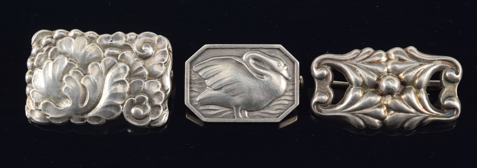Georg Jensen, Denmark. 3 Sterling silver pins. Foliate and bead, #88, Swan #213B, and a floral: Georg Jensen, Denmark. 3 Sterling silver pins. Foliate and bead, #88, Swan #213B, and a floral panel, #192. 0.64 ozt. Longest widths 1 1/4 in.