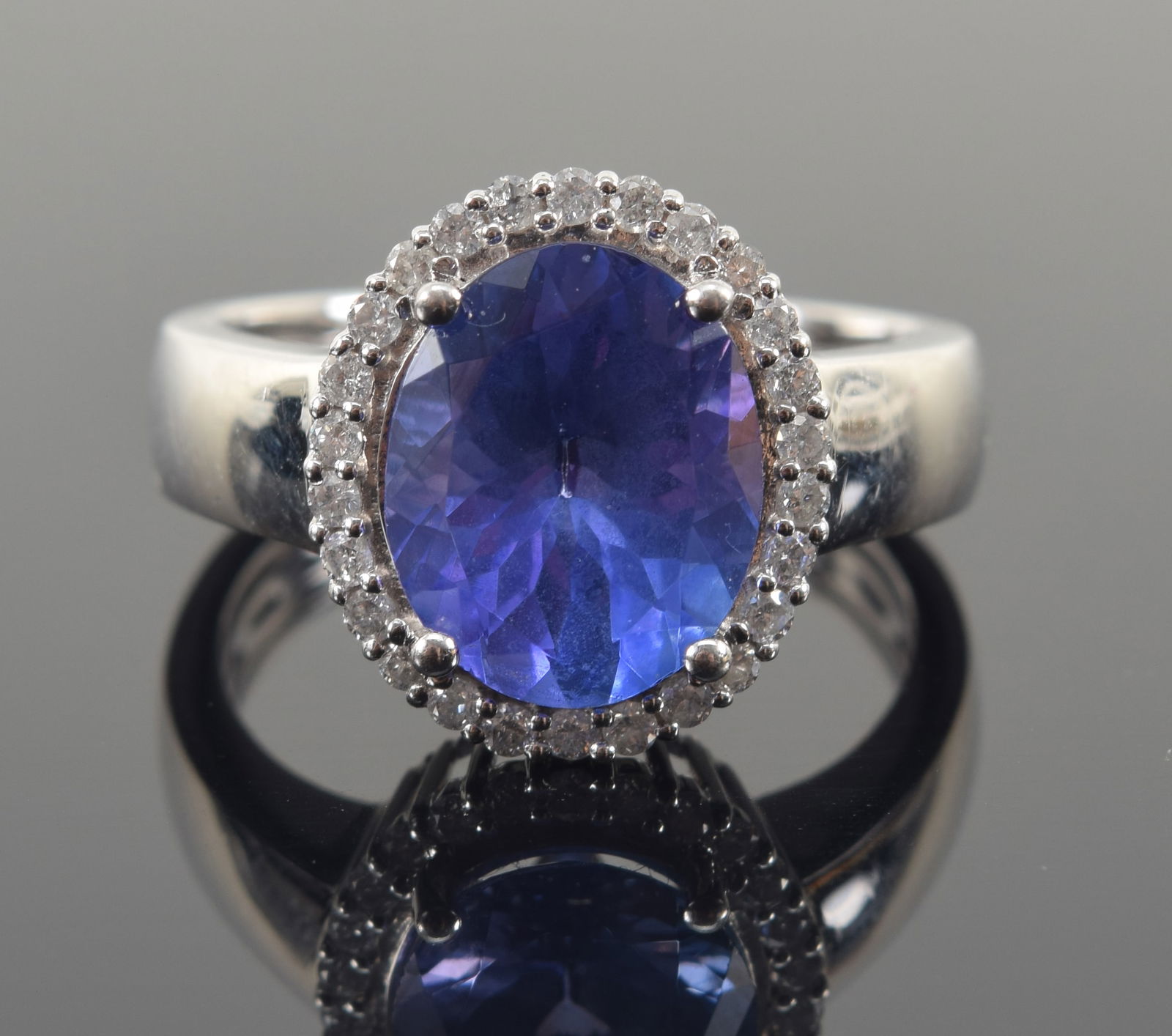 Platinum 3.30 CT tanzanite and diamond mounted ring. Central oval cut tanzanite stone measures: Platinum 3.30 CT tanzanite and diamond mounted ring. Central oval cut tanzanite stone measures approx. 11 x 8.8mm. Halo of small round cut diamonds. Marked PT950 PC. Ring size 7.25. 7.1 grams.