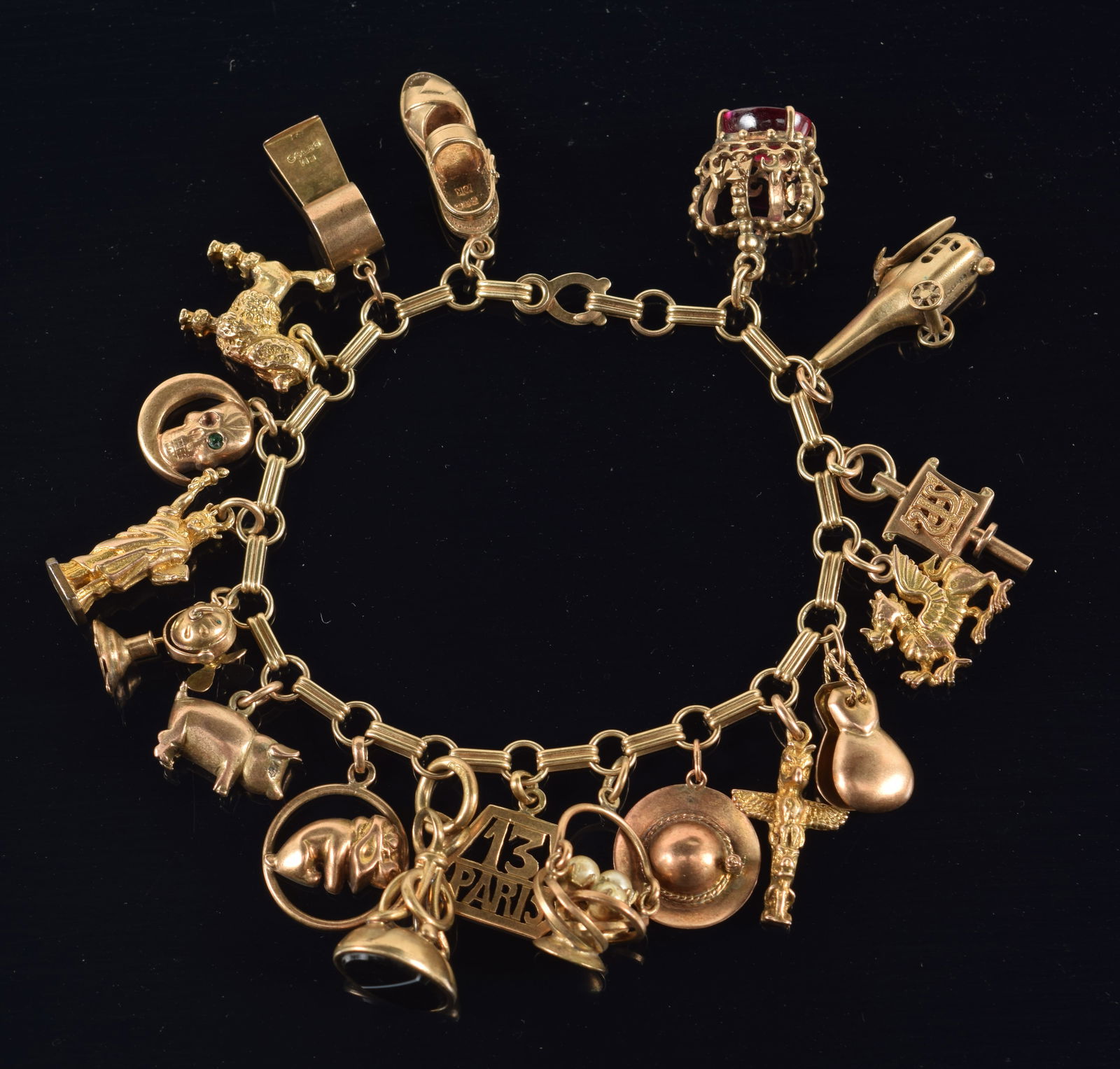14K gold charm bracelet with 18 charms, including animals and other objects of travel. 6 charms: 14K gold charm bracelet with 18 charms, including animals and other objects of travel. 6 charms marked 10K, 1 marked 18K, 10 unmarked but test as 10K, 1 charm is gold filled. Chain clasp marked 14K. C