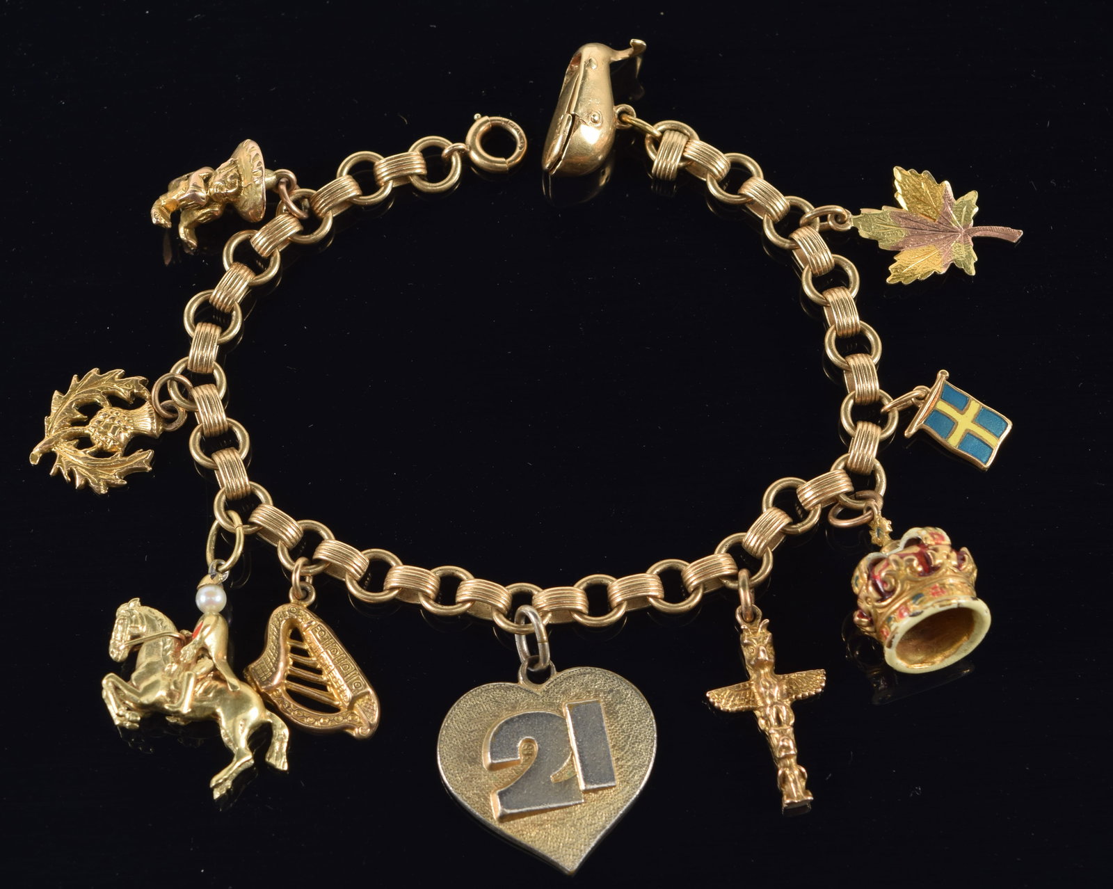 14K gold charm bracelet with 10 charms, including enameled crown, figure on horseback, lyre, totem: 14K gold charm bracelet with 10 charms, including enameled crown, figure on horseback, lyre, totem pole, whale with articulating mouth with fisherman inside, and more. 3 charms marked 10K, 1 charm mar