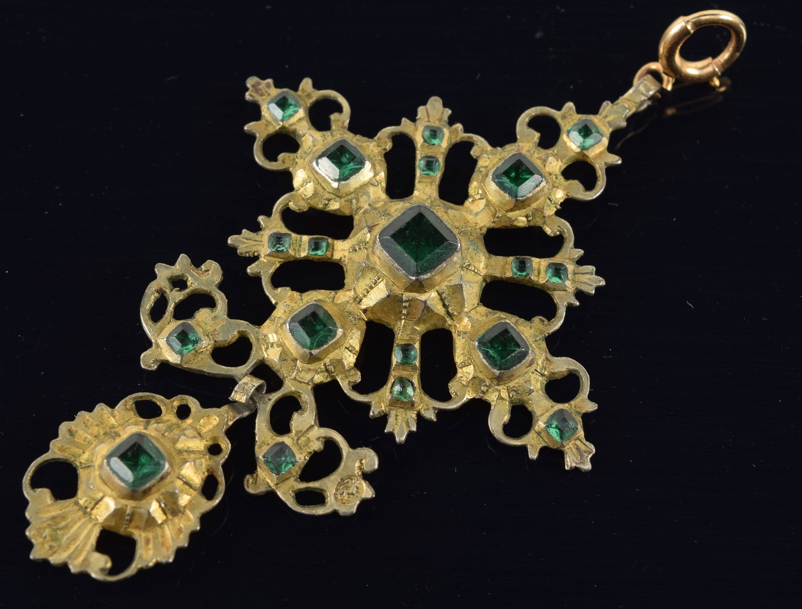 Antique silver cross form pendant. Emerald colored glass stones on a gilt silver reticulated: Antique silver cross form pendant. Emerald colored glass stones on a gilt silver reticulated elaborate cross with drop pendant. Several lion hallmarks. 2.75in long. 9.2 grams.