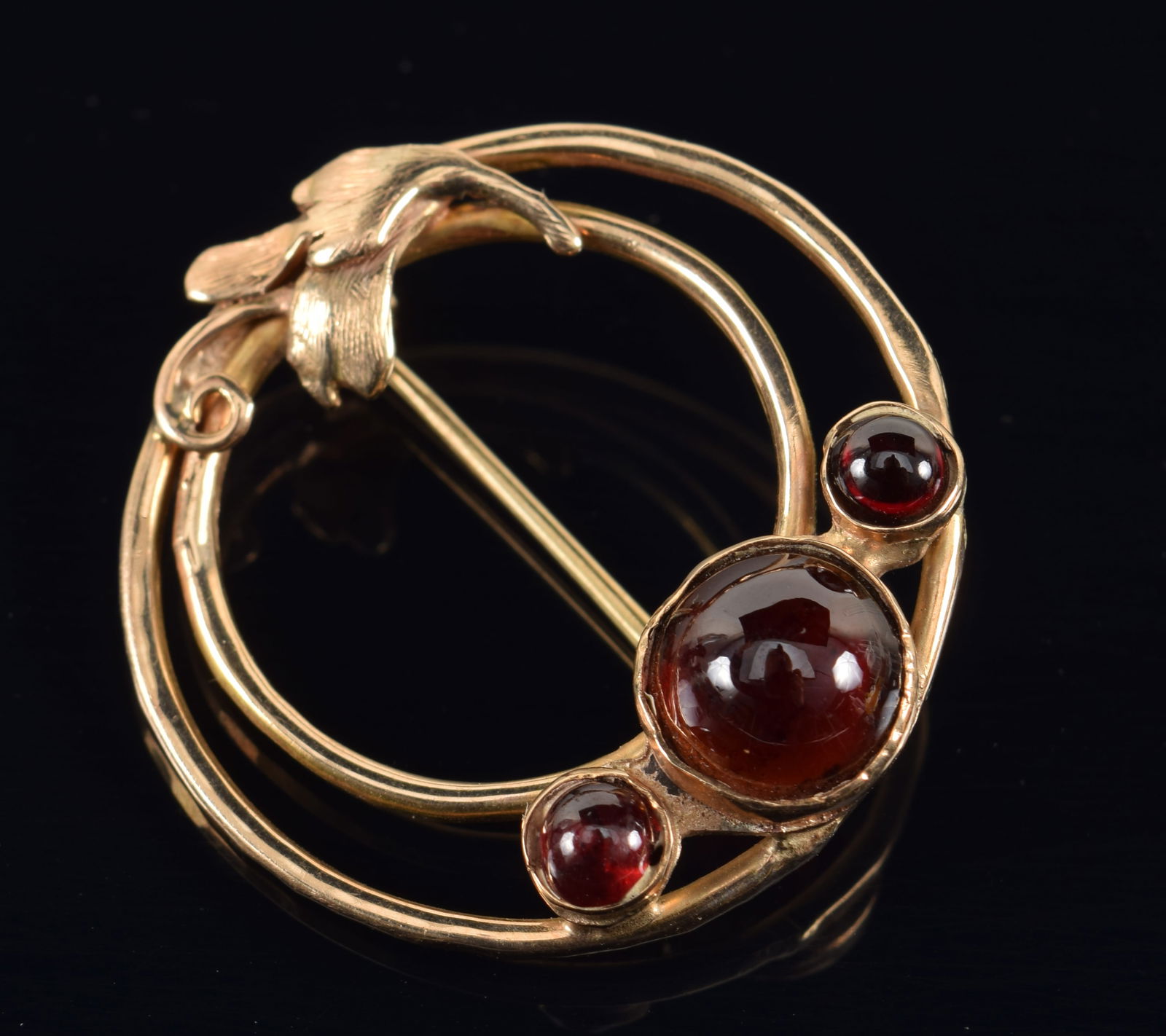 Vintage 14K gold garnet mounted pin. Concentric rings with floral decoration and 3 garnet cabochons.: Vintage 14K gold garnet mounted pin. Concentric rings with floral decoration and 3 garnet cabochons. Marked. 1 1/8in diameter. 5.3 grams.