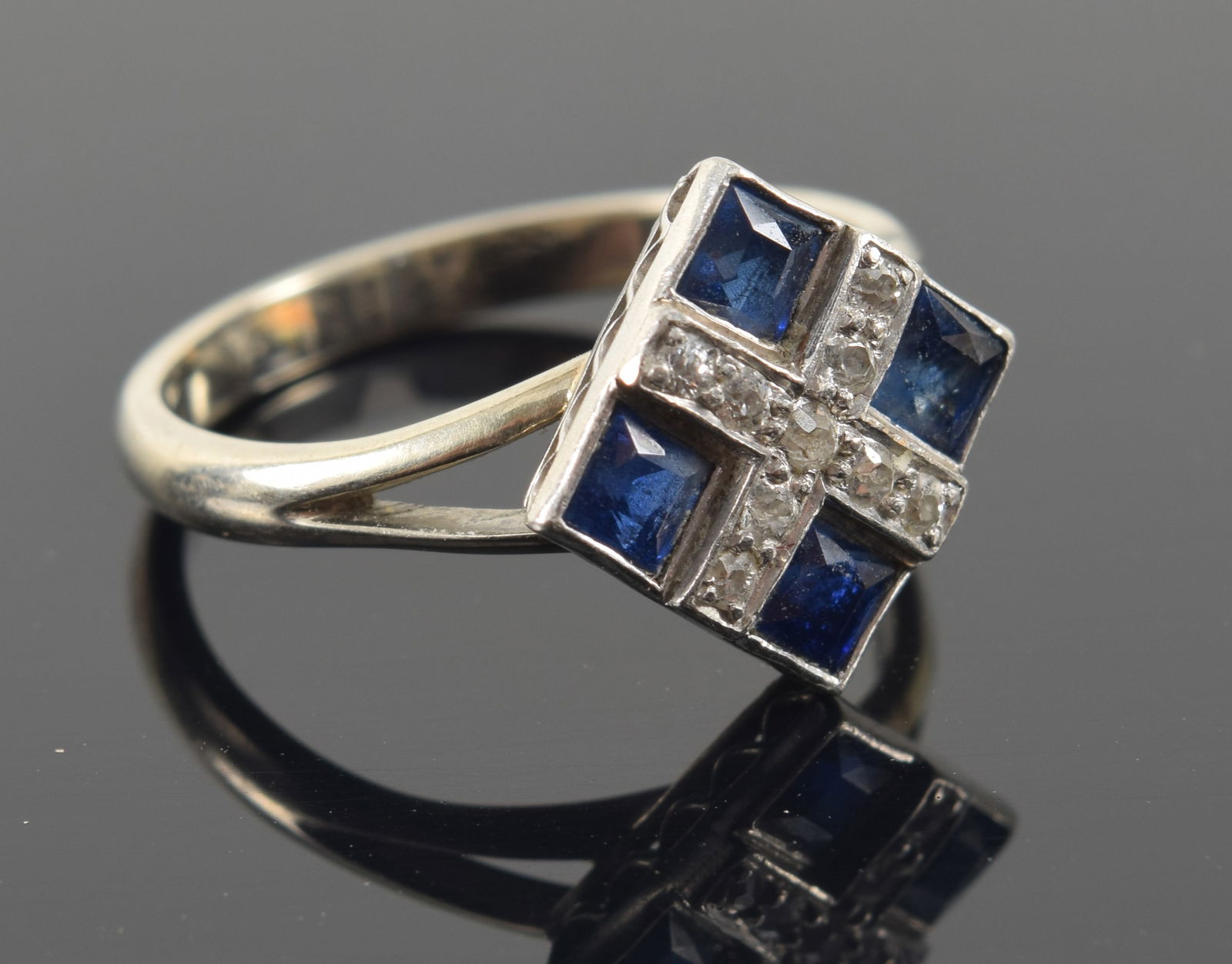 Art Deco 14K white gold sapphire and diamond ring. 4 square cut sapphires (each about 2.8mm): Art Deco 14K white gold sapphire and diamond ring. 4 square cut sapphires (each about 2.8mm) surrounding an X-form channel of small round cut diamonds. Marked 14K. Ring size: 7. 3.8 grams.