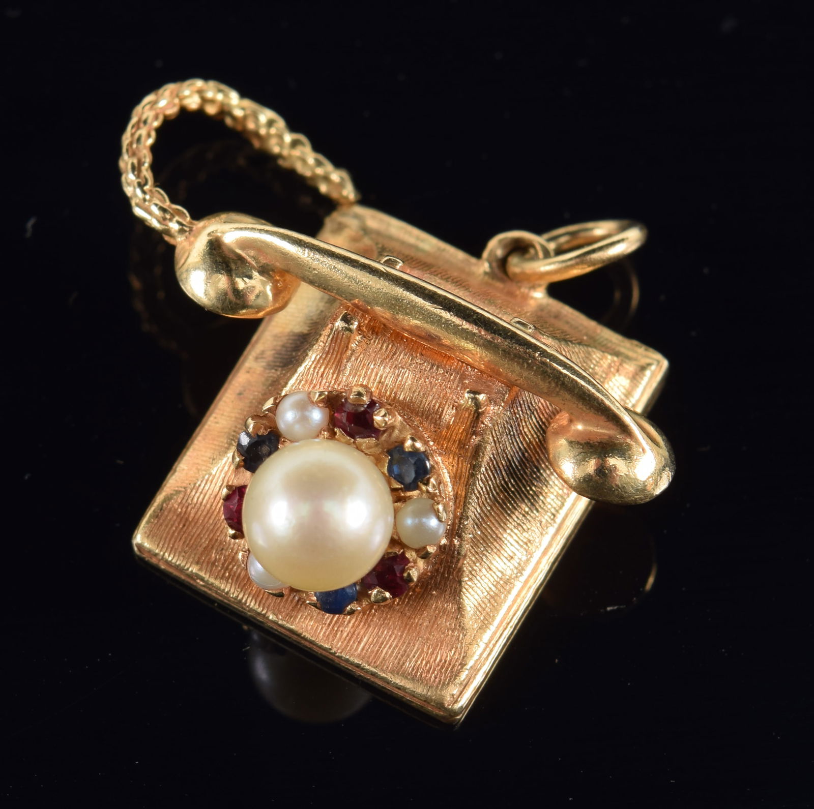 14K gold telephone form charm/pendant. Rotary set with rubies, sapphires, and pearls. Marked 14K and (1 of 4)