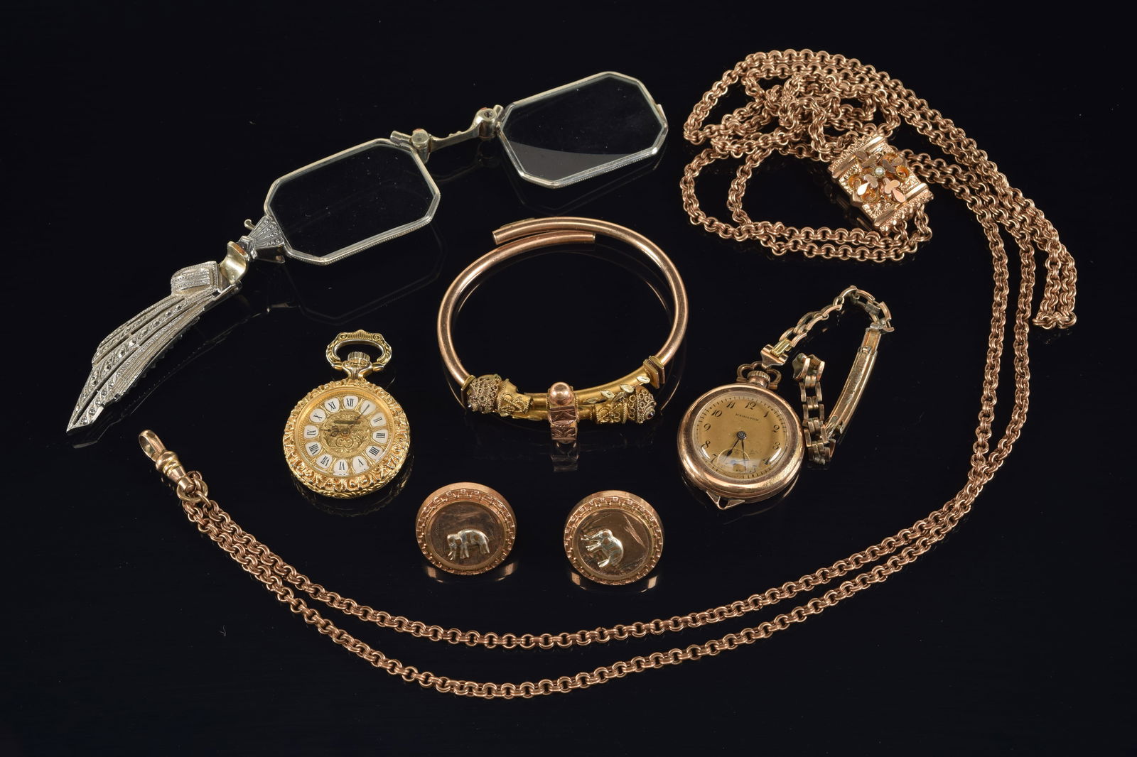 Selection of vintage gold plated jewelry. To include: bracelet, pendent watch, base metal filigree: Selection of vintage gold plated jewelry. To include: bracelet, pendent watch, base metal filigree pocket watch, opera glasses, long chain with slide pendant, and elephant cuff links.