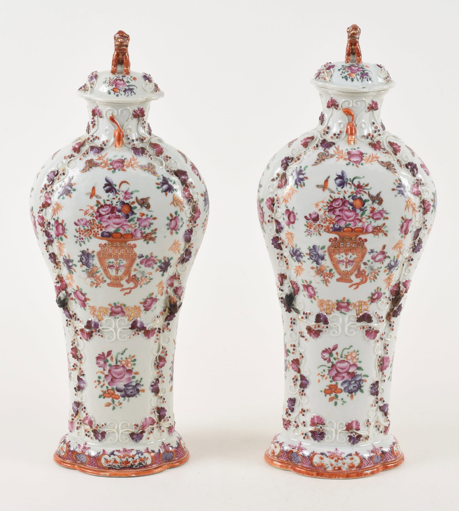 18th century Chinese export porcelain covered vases. Fine quality floral urn motifs with: 18th century Chinese export porcelain covered vases. Fine quality floral urn motifs with butterflies. Foo dog finials. Squirrel and grape decoration. Scattered chips and wear consistent with age. 15.5