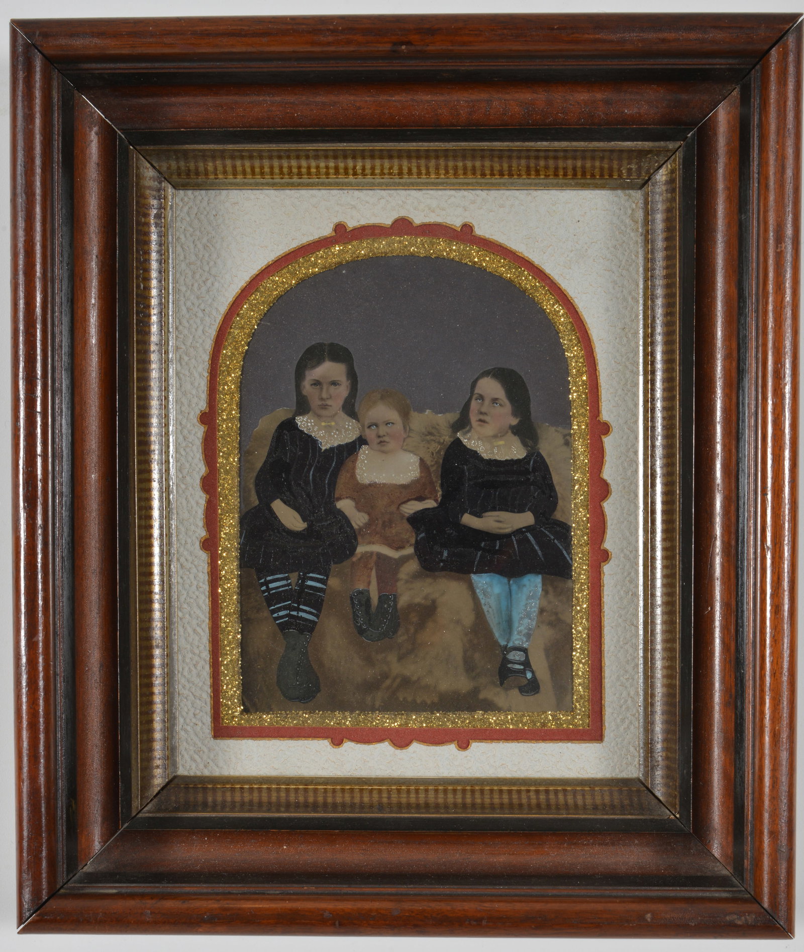 Colored full-plate tintype of 3 young children seated on a large animal fur. Arched mat presentation (1 of 7)