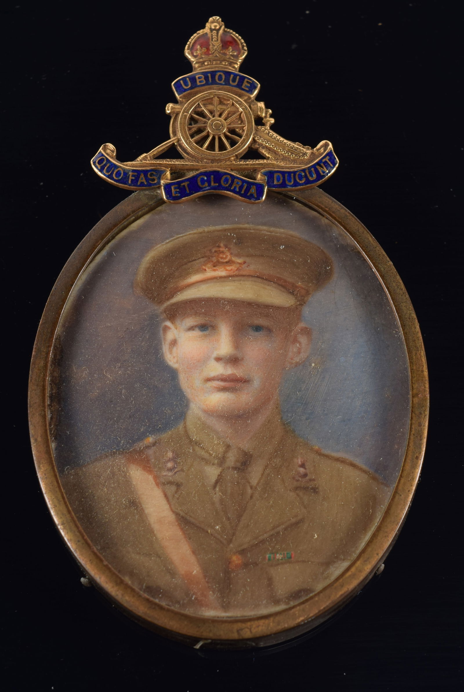 WWI British miniature portrait painting of a young soldier. Brass frame with 14K gold insignia: WWI British miniature portrait painting of a young soldier. Brass frame with 14K gold insignia mounted to the top. Tests 14K. Portrait frame 2.25 x 1.625in without insignia.