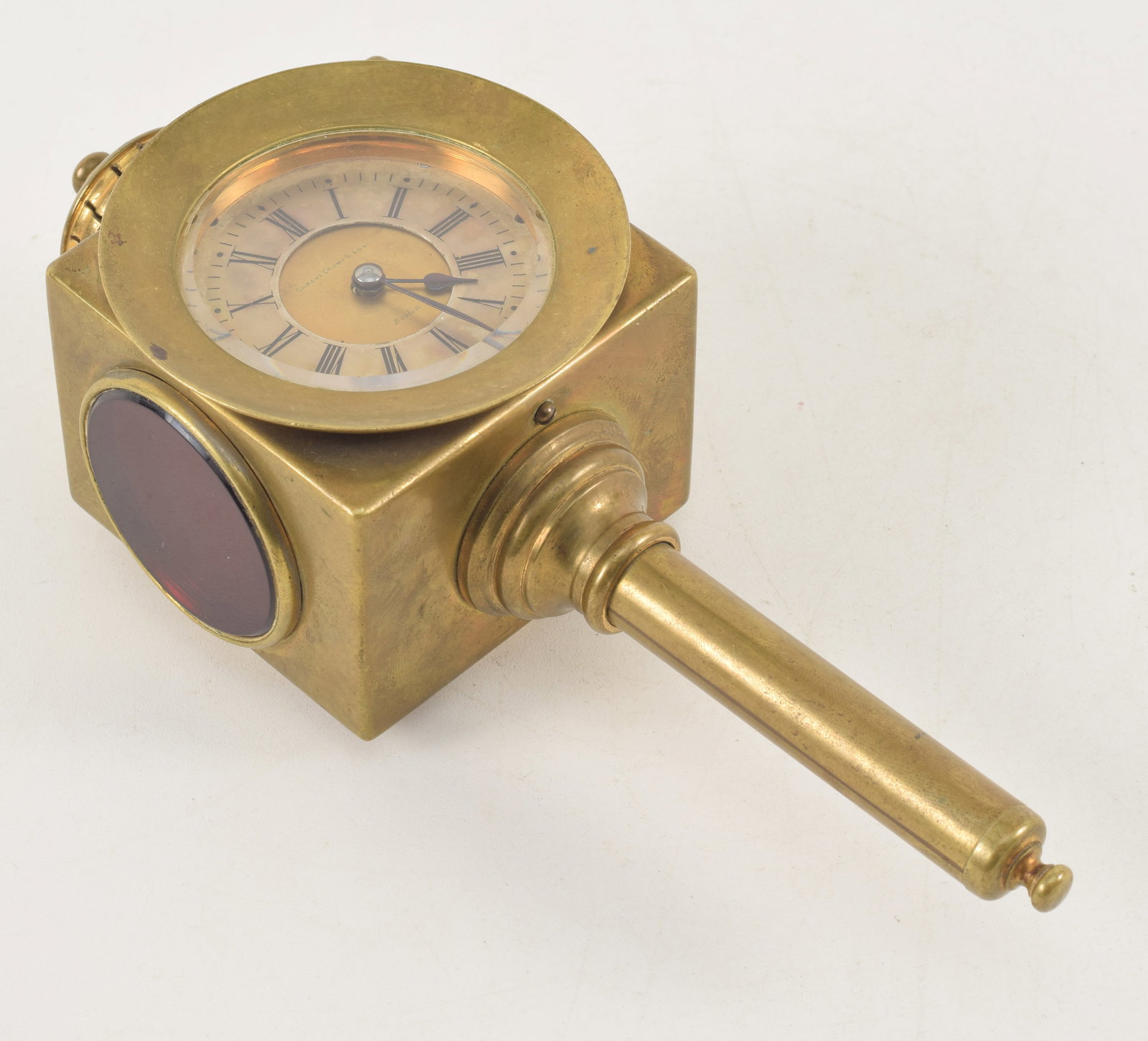 Antique brass carriage lantern clock. Dial marked Shreve Crump & Low Boston. Circular red glass: Antique brass carriage lantern clock. Dial marked Shreve Crump & Low Boston. Circular red glass panels on sides. Works stamped 900 and engraved serial number. Collapsible hanging wall bracket on top.