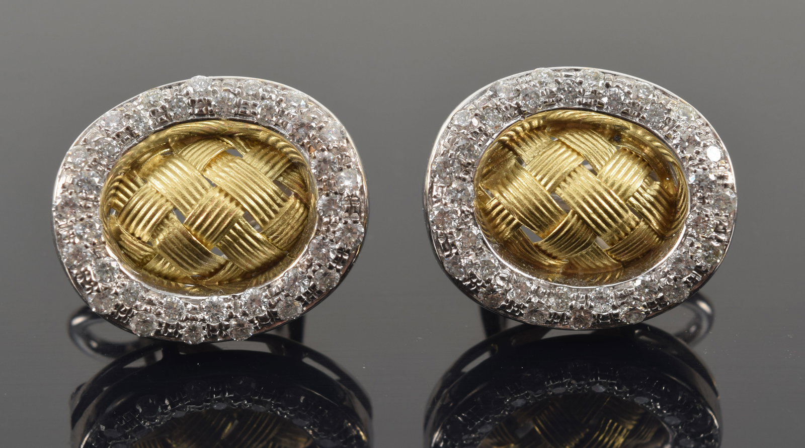 18K white gold diamond earrings with yellow gold reticulated woven centers surrounded by halo of: 18K white gold diamond earrings with yellow gold reticulated woven centers surrounded by halo of pave diamonds. Marked 18K Italy. 0.75in wide. 12.8 grams.