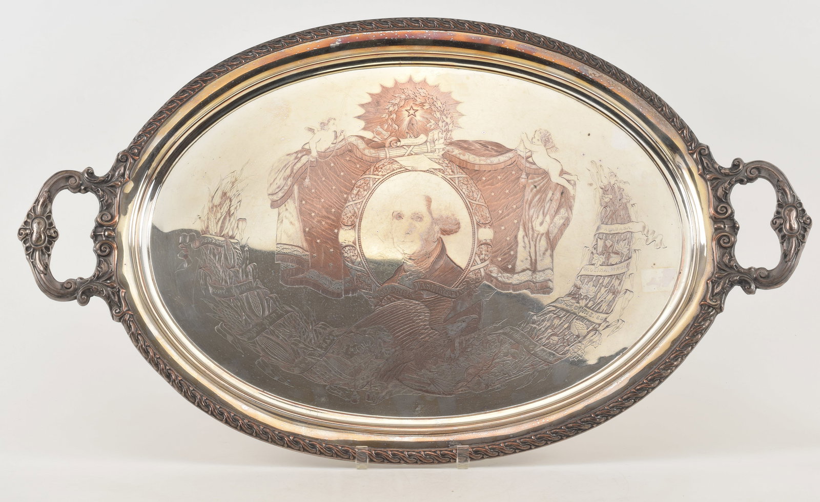 George Washington patriotic engraved plated silver large handle tray, late 19th Century. Engraved: George Washington patriotic engraved plated silver large handle tray, late 19th Century. Engraved with an image of Washington in a cartouche with banners and various patriotic elements with a garland 