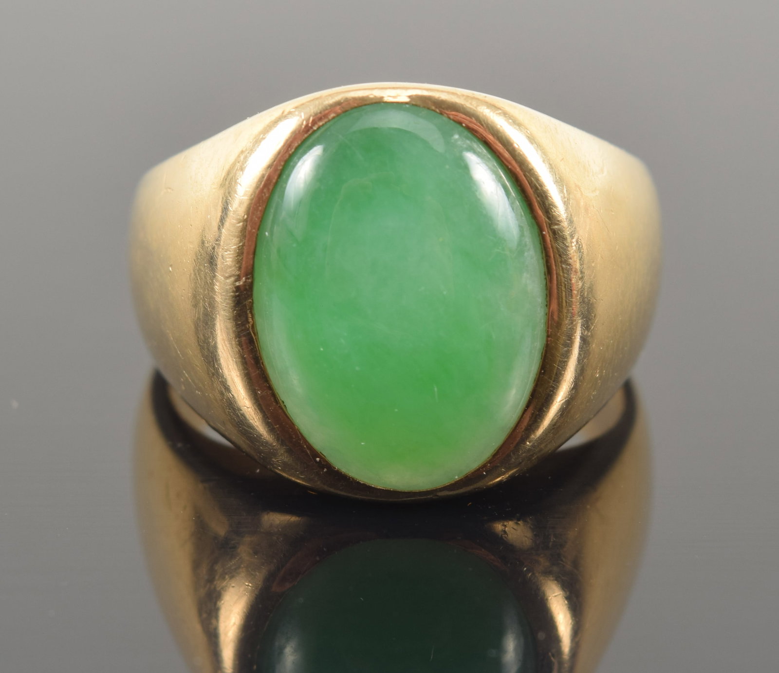 14K gold heavy green jade set ring. Mottled spinach green and celadon jade stone. Measures approx.: 14K gold heavy green jade set ring. Mottled spinach green and celadon jade stone. Measures approx. 14 x 10.2mm. Stamped 14K. Ring size 7.25. 11.4 grams.