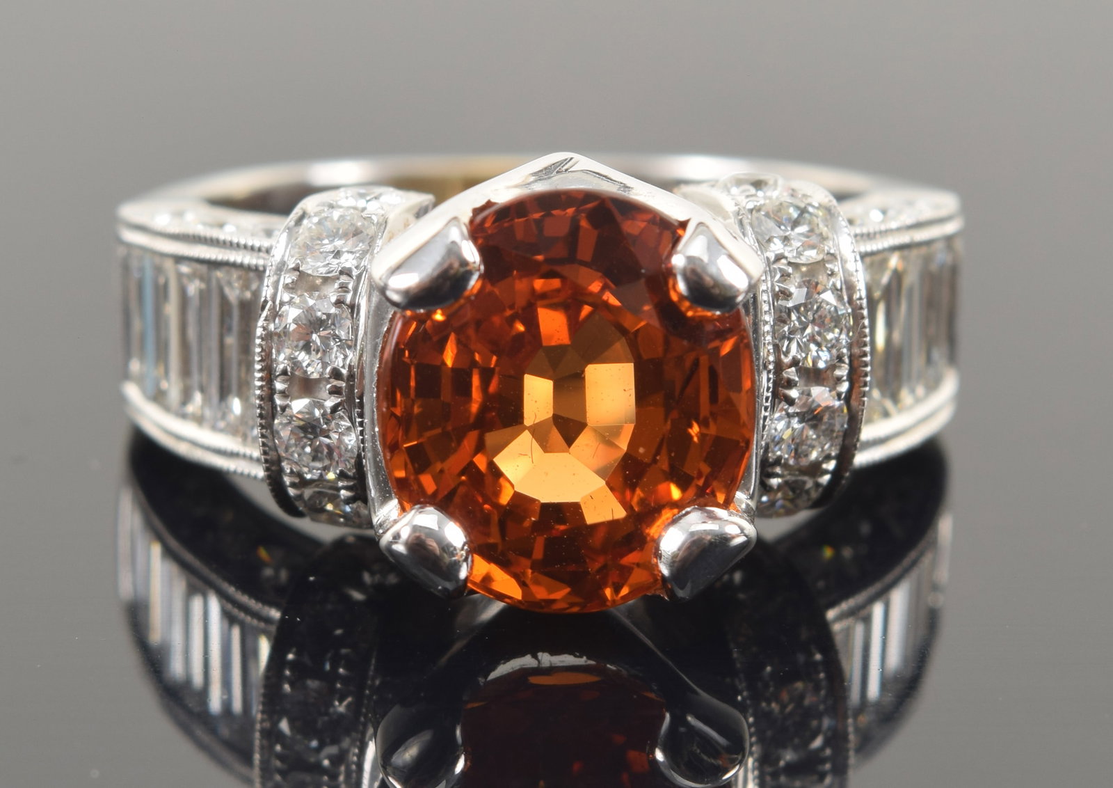 18K white gold 6.42CT spessartite (Mandarin) garnet and diamond ring. Oval cut garnet measuring 10.7: 18K white gold 6.42CT spessartite (Mandarin) garnet and diamond ring. Oval cut garnet measuring 10.7 x 9.4 x 6.1mm and weighing 6.42ct. Orange color with medium-dark tone. Eye clean clarity. Flanked b