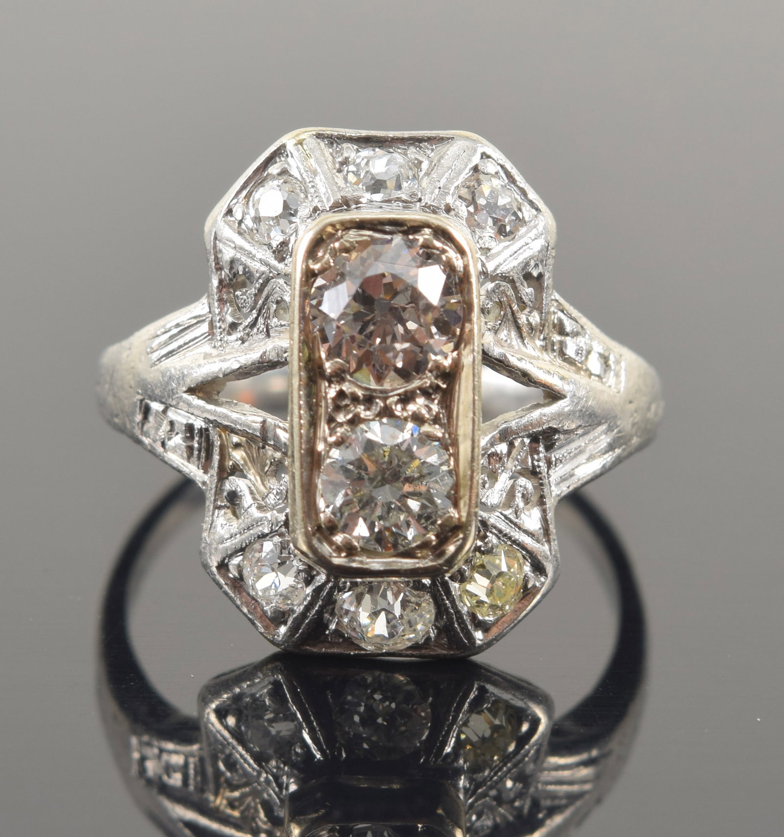 Edwardian platinum and diamond ring. Two central diamonds: one old European cut weighing approx.: Edwardian platinum and diamond ring. Two central diamonds: one old European cut weighing approx. 0.40ct; one round brilliant cut weighing approx. 0.25ct. Gallery with 6 round diamonds. Reticulated scr
