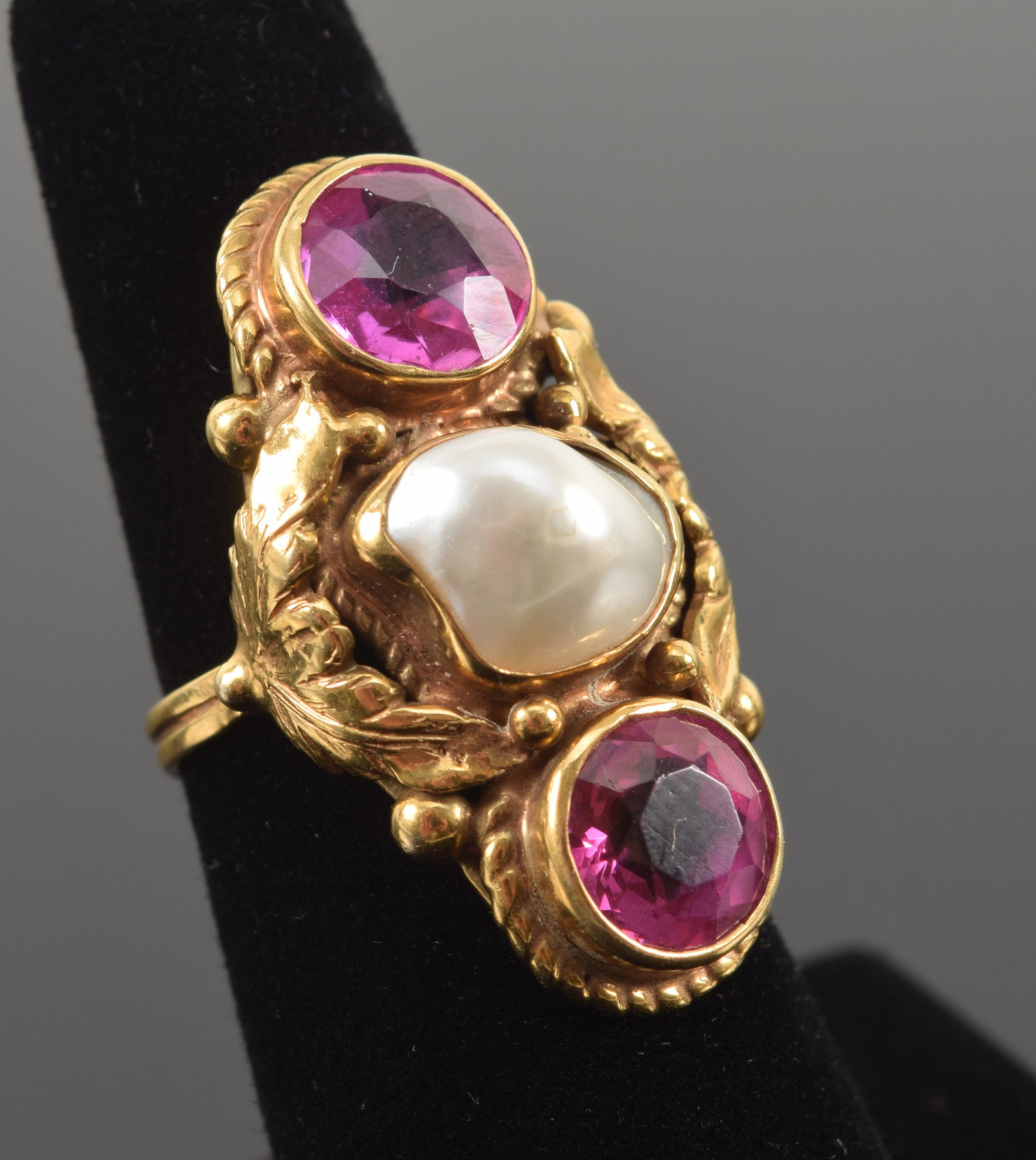 Antique 14K gold pink sapphire and baroque pearl mounted ring. 2 pink stones, one tests as sapphire: Antique 14K gold pink sapphire and baroque pearl mounted ring. 2 pink stones, one tests as sapphire (darker color), the other tests as less than glass. Sapphire stone approx. 8.2mm diameter. Leaf and 