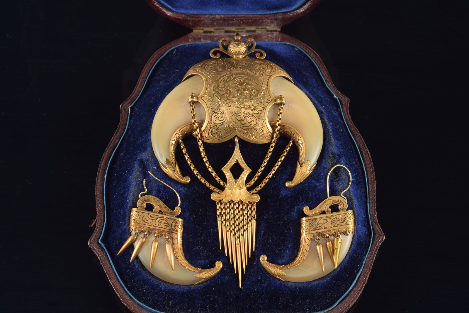 19th century Indian gold tiger claw mounted jewelry suite. Symmetrical double tiger claw brooch with: 19th century Indian gold tiger claw mounted jewelry suite. Symmetrical double tiger claw brooch with elaborately engraved gold panel and mountings. Chained drop pendants. Matching earrings. Brooch wit