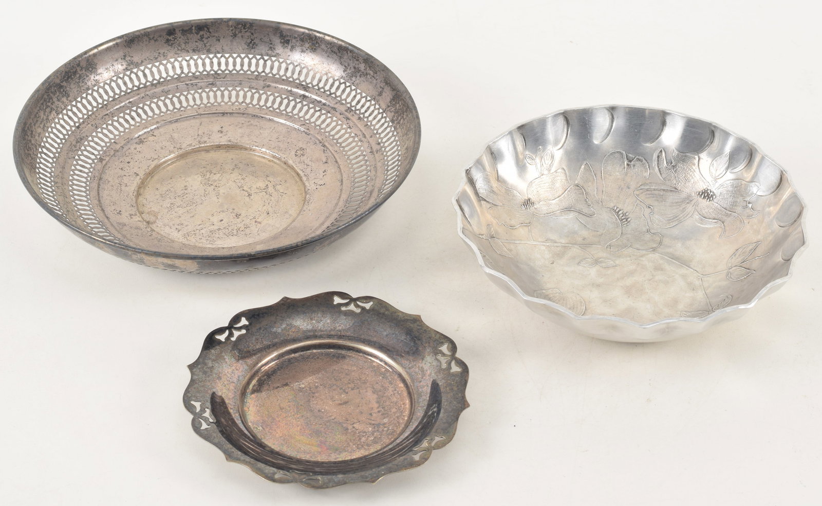 Sterling silver reticulated dish. 8.75in diameter. 5.3 ozt. Together with a silver plated pierced: Sterling silver reticulated dish. 8.75in diameter. 5.3 ozt. Together with a silver plated pierced bow-design small dish and a Wendell August forge early aluminum decorated dish. Marked on base.