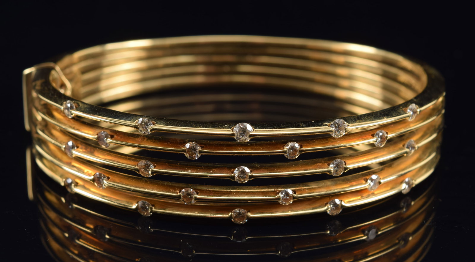 14K gold multi strand diamond mounted bracelet. Hinged bangle design. Slightly tapered strands.: 14K gold multi strand diamond mounted bracelet. Hinged bangle design. Slightly tapered strands. Clasp marked 14K Italy. 2.75in wide. 31.7 grams.