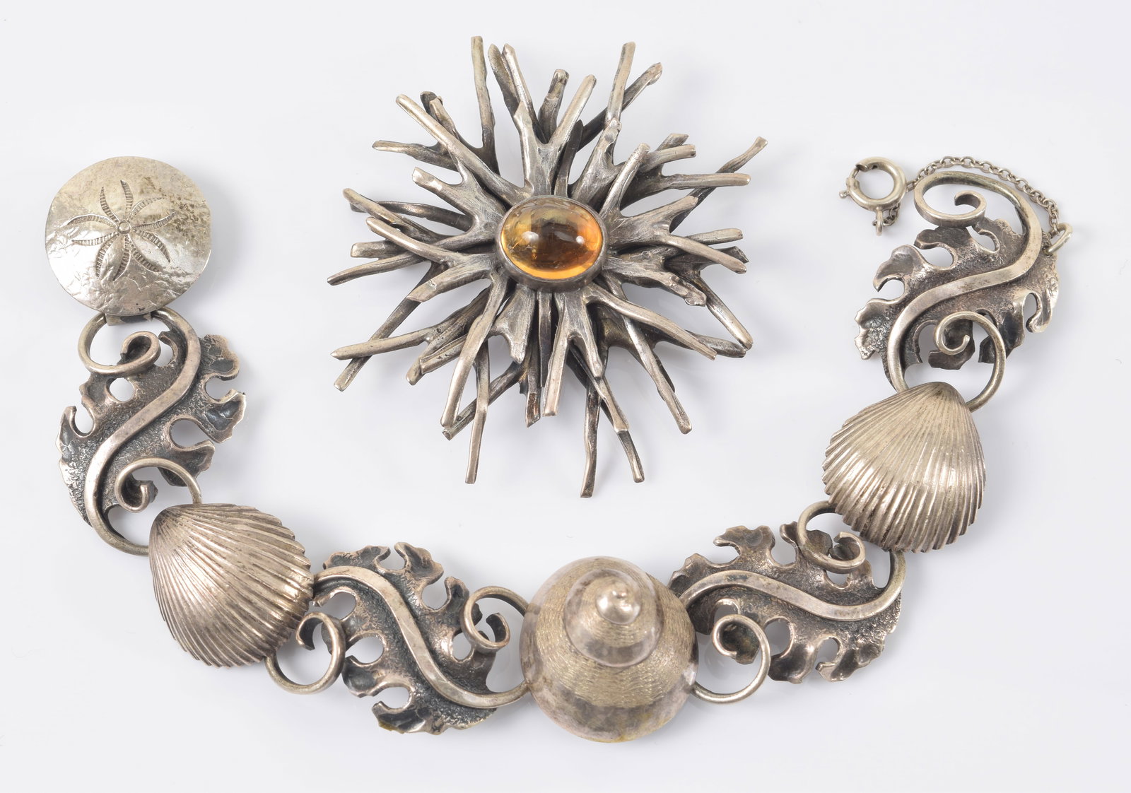 Clifford Russell. Maine. Sterling silver ocean themed jewelry. 1) Driftwood cluster pin set with: Clifford Russell. Maine. Sterling silver ocean themed jewelry. 1) Driftwood cluster pin set with oval citrine cabochon. Signed on reverse. 2in diameter. 2) Bracelet with marine life, including kelp le