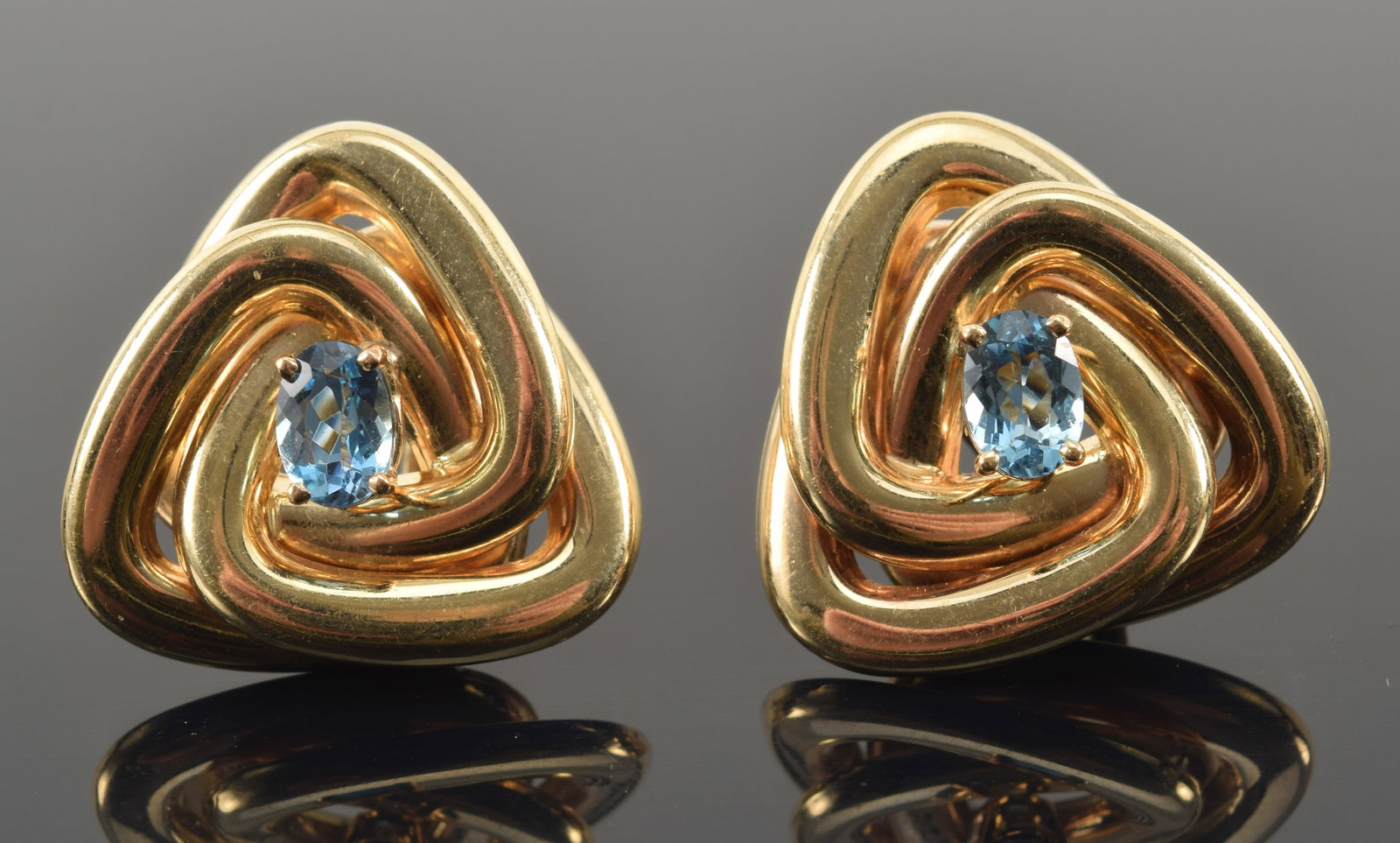 14K gold blue topaz mounted earrings with interlocked triangular form. Topaz stones measure approx.: 14K gold blue topaz mounted earrings with interlocked triangular form. Topaz stones measure approx. 6.9 x 4.9mm. Marked 14K, Italy, and DD on reverse. 1in length. 13.4 grams.